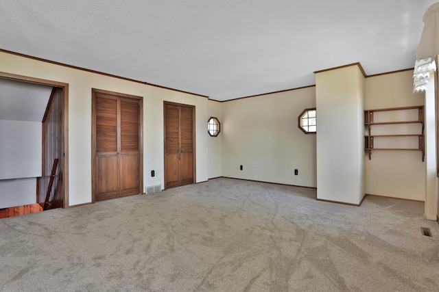 1379 7th Ave SE, Forest Lake, MN 55025 - unfurnished bedroom with carpet flooring, crown molding, multiple closets, and baseboards
