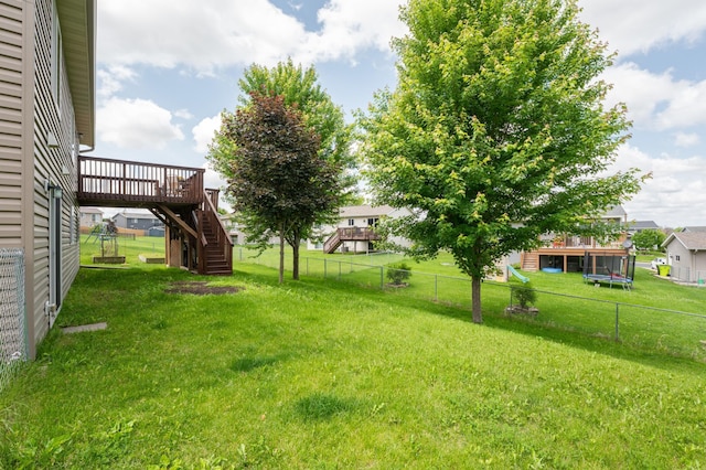 829 Dubuque Blvd, Zumbrota, MN 55992 - fenced backyard featuring stairs, a wooden deck, and a trampoline