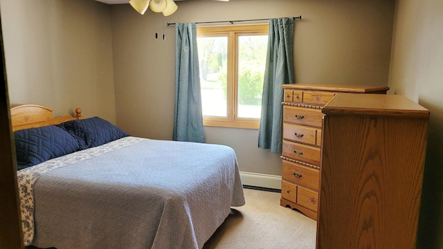 bedroom with a baseboard radiator, light colored carpet, and baseboards