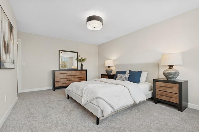 bedroom with light carpet and baseboards