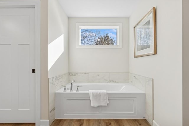 full bath with a garden tub and wood finished floors