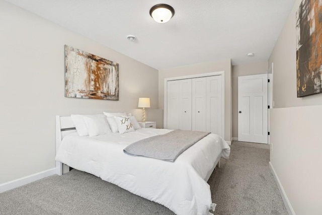 carpeted bedroom featuring a closet and baseboards