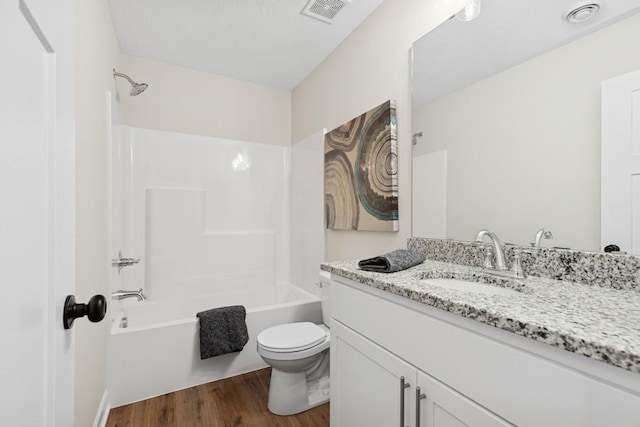 full bathroom featuring toilet, wood finished floors,  shower combination, and vanity