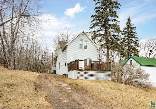 rear view of property with a wooden deck and an outdoor structure