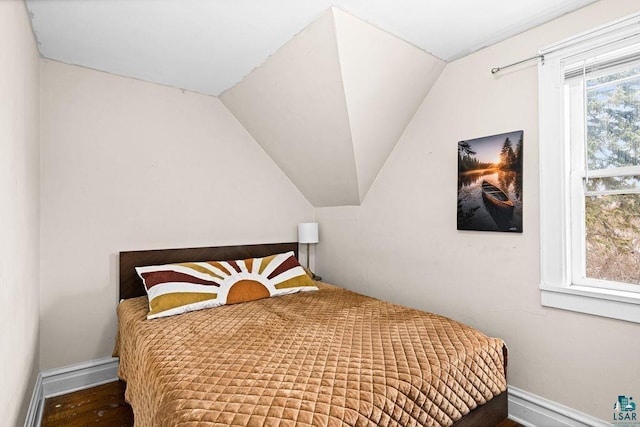 bedroom featuring vaulted ceiling and baseboards