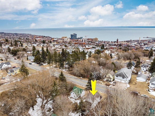 aerial view of property's location featuring a large body of water and nearby suburban area