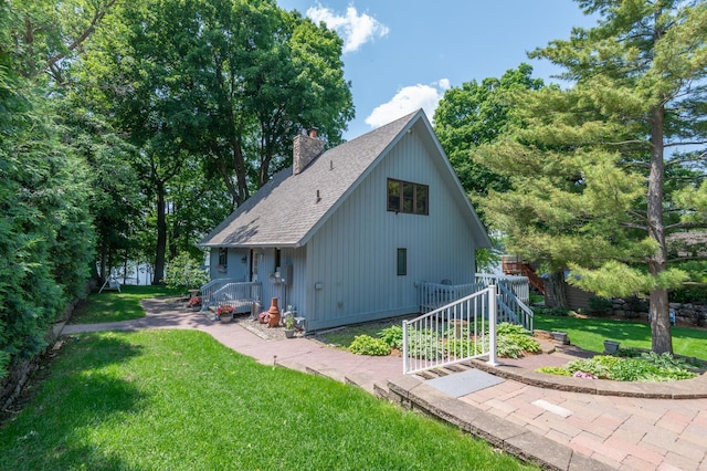 1749 Avocet Ln, Mound, MN 55364 - view of home's exterior featuring a shingled roof, a chimney, and a yard
