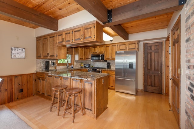 1749 Avocet Ln, Mound, MN 55364 - kitchen featuring stainless steel appliances, brown cabinets, a peninsula, light wood finished floors, and a wood ceiling with exposed beams