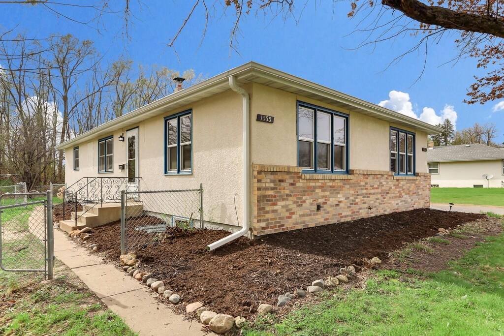 1555 Mcafee St, Saint Paul, MN 55106 - view of side of property with fence, brick siding, and stucco siding