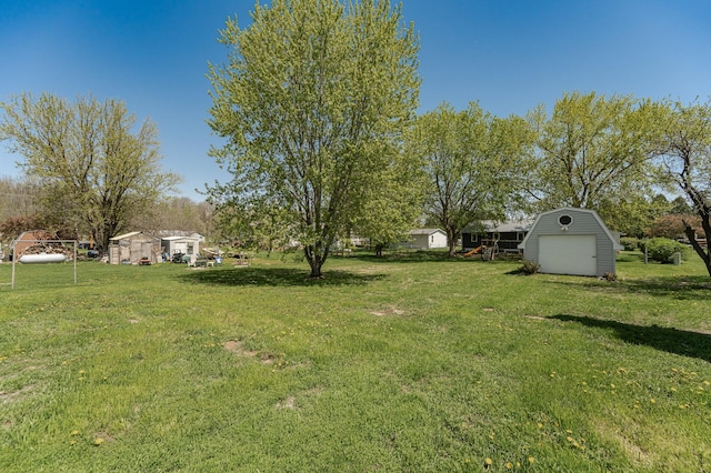 view of grassy yard featuring an outdoor structure, a storage unit, and a garage