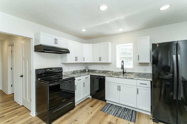 kitchen featuring black appliances, under cabinet range hood, a sink, white cabinets, and recessed lighting