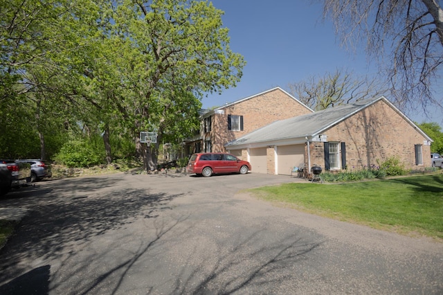 1345 Crestridge Ln Unit 203, Eagan, MN 55123 - view of front of property featuring a front lawn, brick siding, asphalt driveway, and a garage