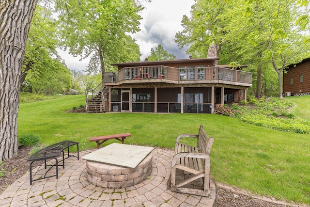 22005 Statesboro Trl, Clitherall, MN 56524 - back of property with an outdoor fire pit, a deck, stairway, and a yard