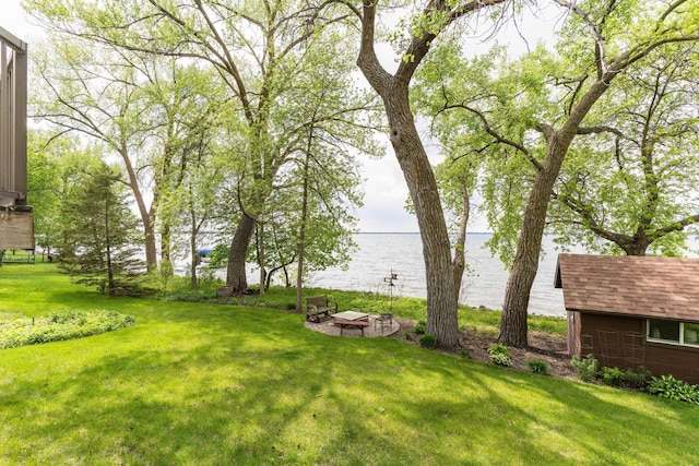22005 Statesboro Trl, Clitherall, MN 56524 - view of grassy yard featuring a water view, an outbuilding, and a fire pit