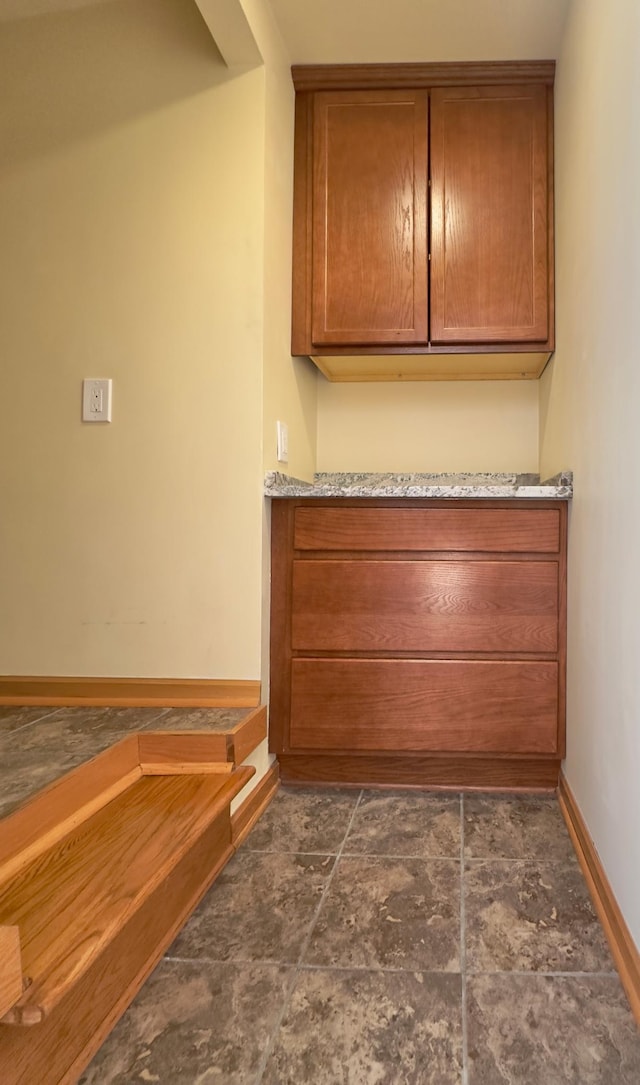 bar featuring baseboards and dark stone finish flooring