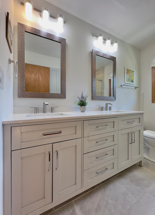 bathroom with toilet, tile patterned flooring, and double vanity