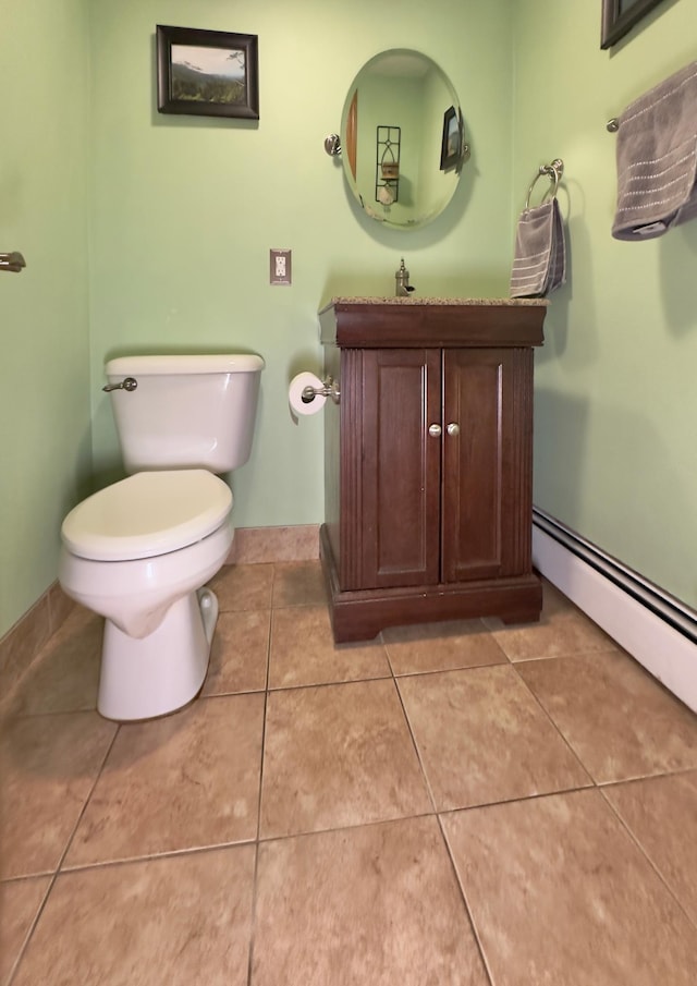 bathroom featuring toilet, tile patterned flooring, vanity, baseboards, and a baseboard heating unit