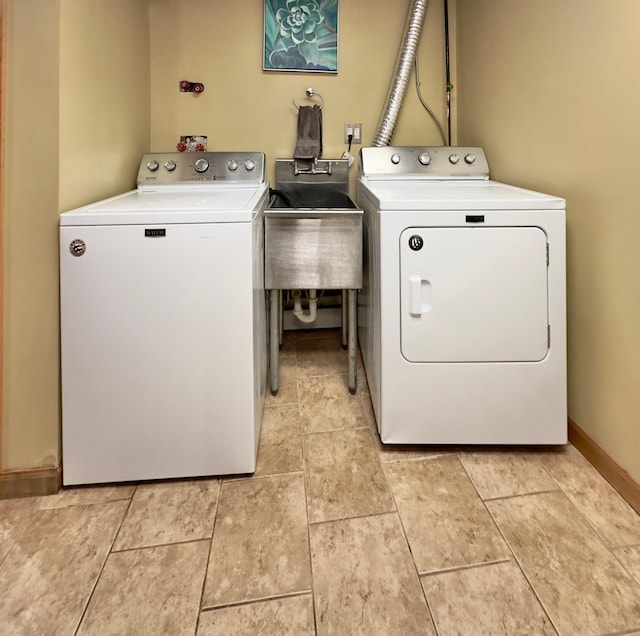 laundry room with washing machine and clothes dryer and baseboards