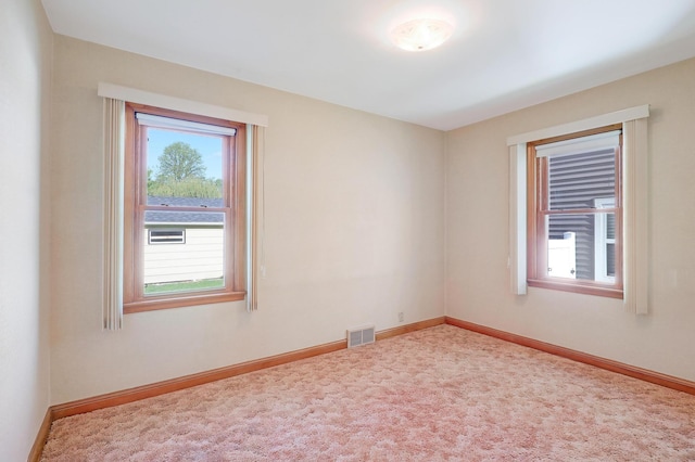 carpeted empty room featuring baseboards