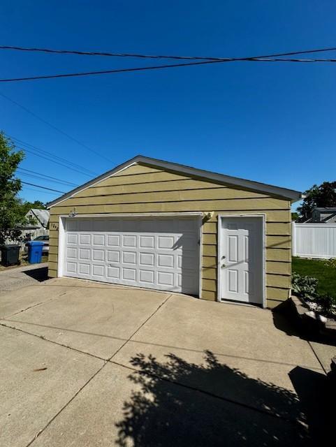 detached garage featuring fence