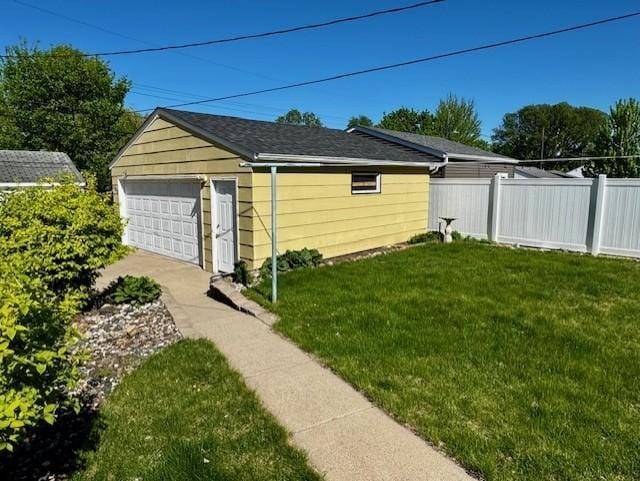 view of yard with a garage and an outbuilding