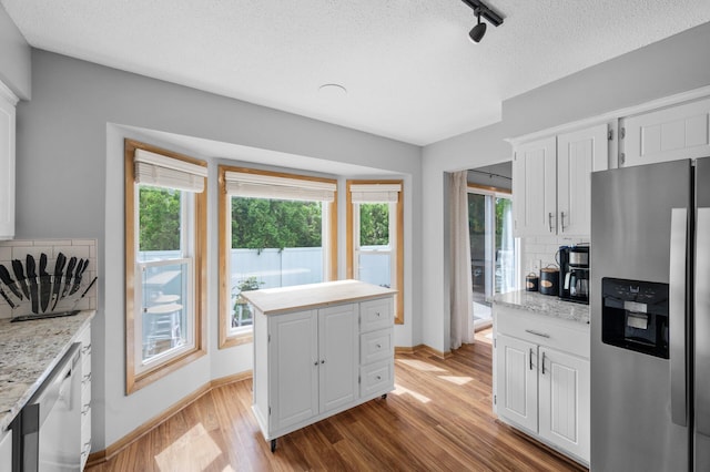 1428 Willow Creek Ln, Shoreview, MN 55126 - kitchen featuring stainless steel appliances, decorative backsplash, light wood-style floors, baseboards, and white cabinetry