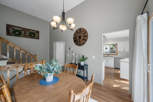 1428 Willow Creek Ln, Shoreview, MN 55126 - dining room with light wood-style floors, a chandelier, high vaulted ceiling, and baseboards