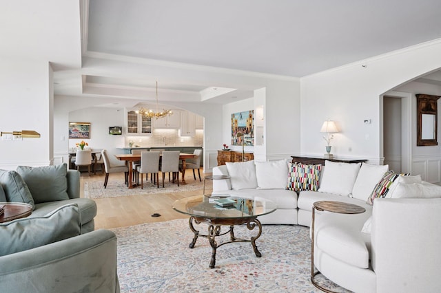 1201 Yale Pl Unit 2102, Minneapolis, MN 55403 - living area featuring arched walkways, light wood-type flooring, a chandelier, wainscoting, and ornamental molding