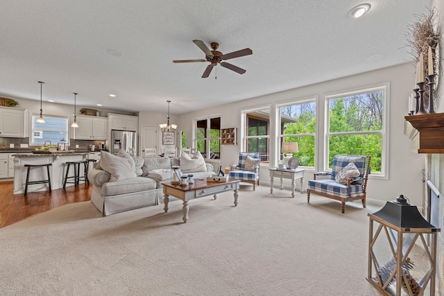 3121 Wild Flower Trl, Medina, MN 55340 - carpeted living room featuring a ceiling fan, a chandelier, recessed lighting, wood finished floors, and a sink