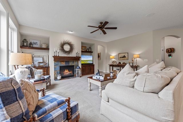 3121 Wild Flower Trl, Medina, MN 55340 - carpeted living room featuring arched walkways, ceiling fan, and a fireplace