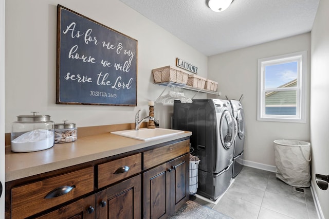 3121 Wild Flower Trl, Medina, MN 55340 - washroom featuring washer and dryer, cabinet space, baseboards, light tile patterned flooring, and a textured ceiling