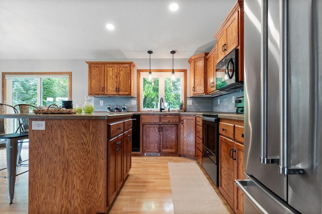 2820 Wilderness Ridge Rd SE, Alexandria, MN 56308 - kitchen with black appliances, light wood-type flooring, decorative backsplash, a breakfast bar area, and recessed lighting