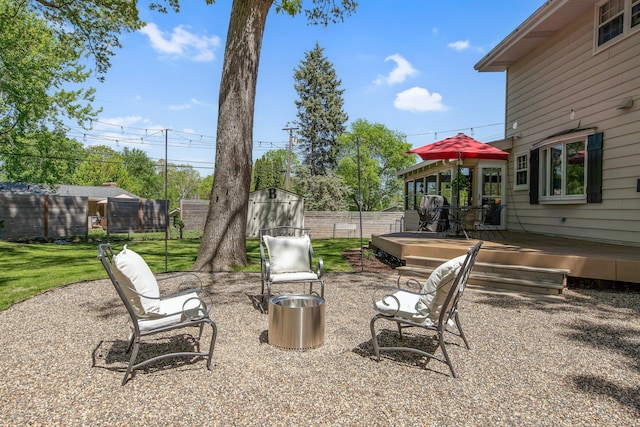 view of yard featuring a deck, an outbuilding, a shed, and a patio area