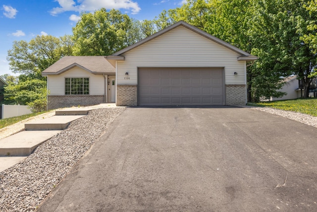 single story home with brick siding, driveway, and an attached garage
