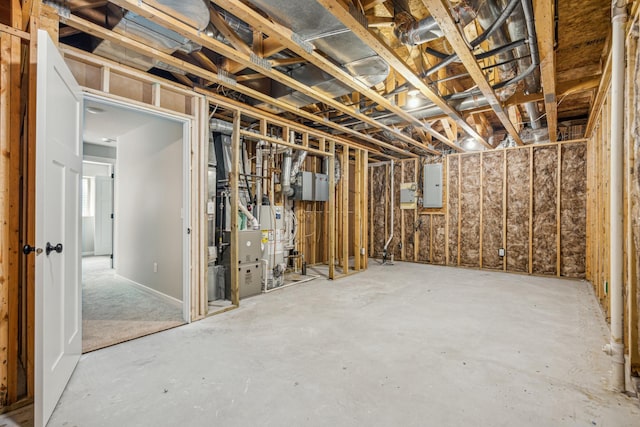 unfinished below grade area with electric panel and water heater