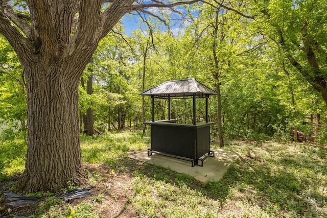 view of yard featuring a gazebo and a wooded view