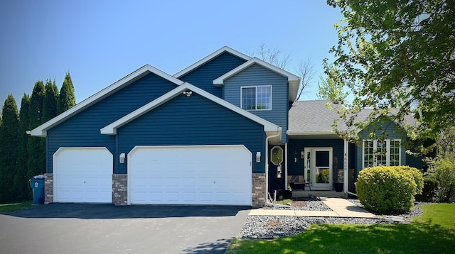 6609 210th Ln N, Forest Lake, MN 55025 - view of front of house with driveway, an attached garage, and stone siding