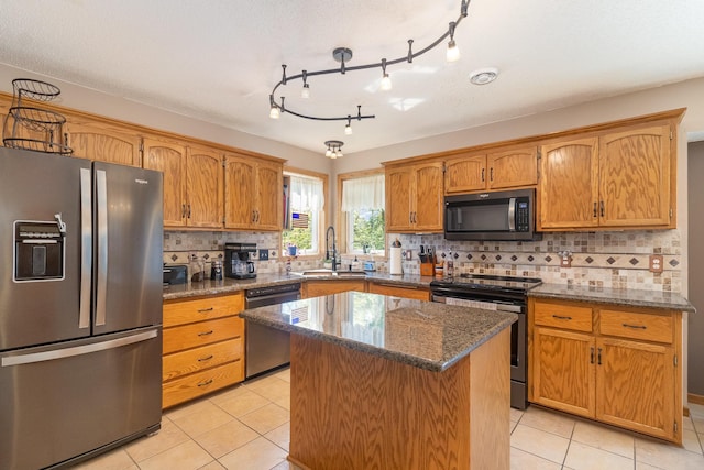 6609 210th Ln N, Forest Lake, MN 55025 - kitchen with stainless steel appliances, light tile patterned flooring, a center island, and dark stone countertops