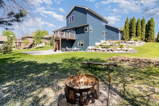 6609 210th Ln N, Forest Lake, MN 55025 - back of property featuring an outdoor fire pit, a yard, a wooden deck, and a patio area