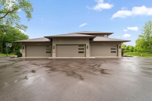 18565 Revere Ave, Spring Lake Twp, MN 55372 - view of front facade featuring asphalt driveway, an attached garage, stone siding, and roof with shingles