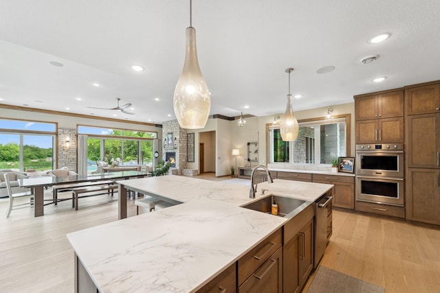 18565 Revere Ave, Spring Lake Twp, MN 55372 - kitchen with a sink, stainless steel appliances, open floor plan, light wood-style floors, and pendant lighting