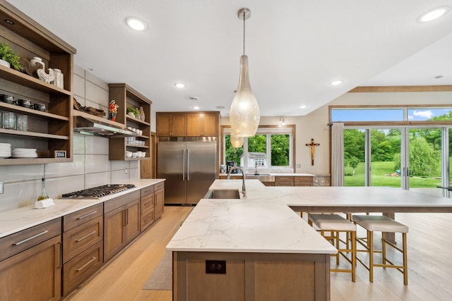 18565 Revere Ave, Spring Lake Twp, MN 55372 - kitchen with open shelves, appliances with stainless steel finishes, a sink, a center island with sink, and light wood-type flooring