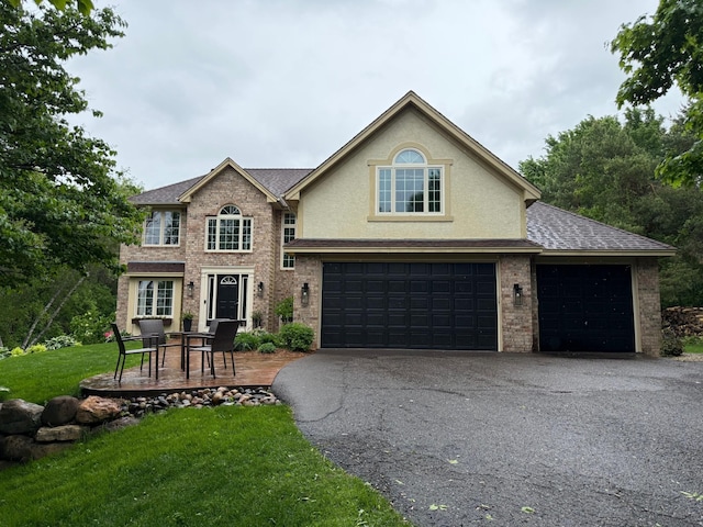 5640 Parnell Ave NE, Saint Michael, MN 55376 - view of front of home with asphalt driveway, a front lawn, stucco siding, a shingled roof, and brick siding
