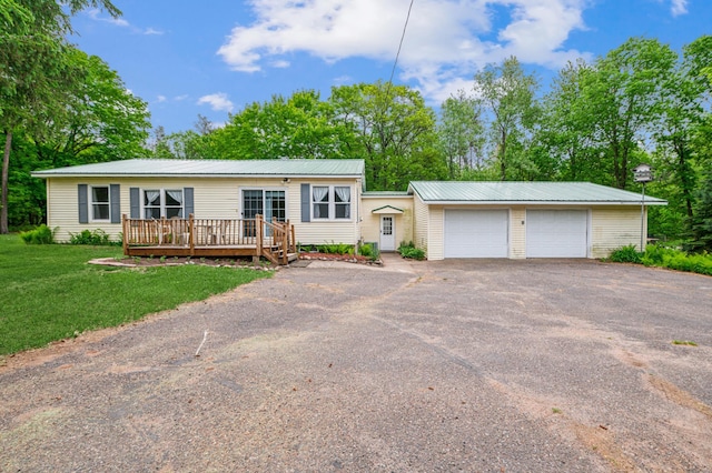 2628 River Rd, Sterling Twp, WI 54024 - view of front of home with asphalt driveway, a deck, a front yard, metal roof, and a garage