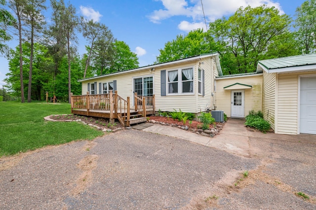 2628 River Rd, Sterling Twp, WI 54024 - view of front facade with a wooden deck, a front yard, central AC unit, and driveway