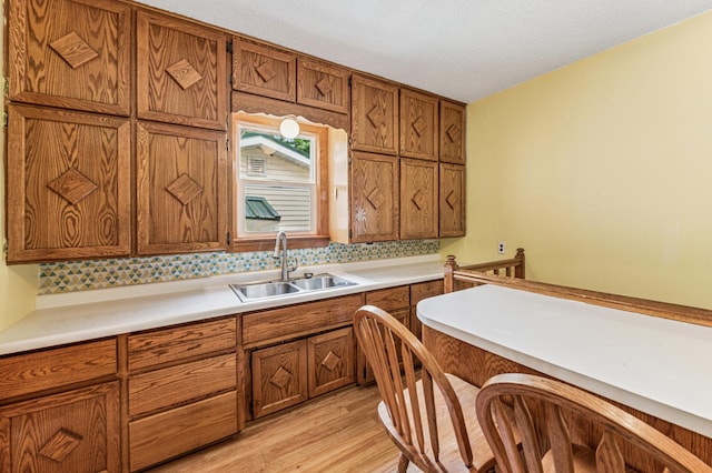 2628 River Rd, Sterling Twp, WI 54024 - kitchen with a sink, brown cabinets, light wood-type flooring, and light countertops