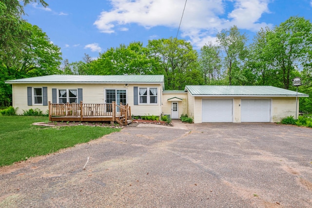 2628 River Rd, Sterling Twp, WI 54024 - view of front of home with a wooden deck, asphalt driveway, a front lawn, and metal roof