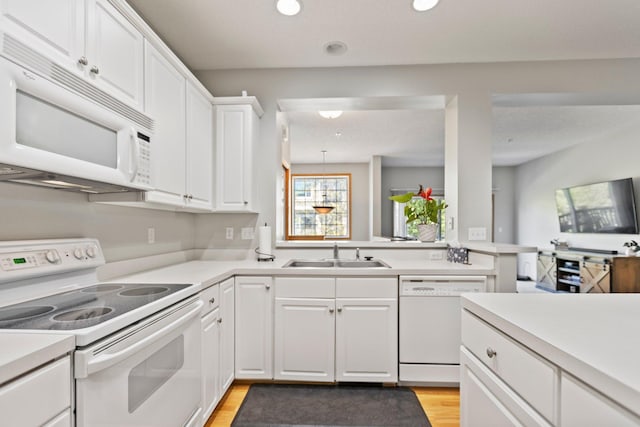 13848 52nd Ave N, Plymouth, MN 55446 - kitchen with white appliances, a sink, light countertops, white cabinets, and light wood-style floors