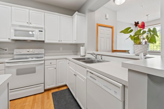 13848 52nd Ave N, Plymouth, MN 55446 - kitchen with white appliances, a sink, light countertops, light wood-style flooring, and white cabinets