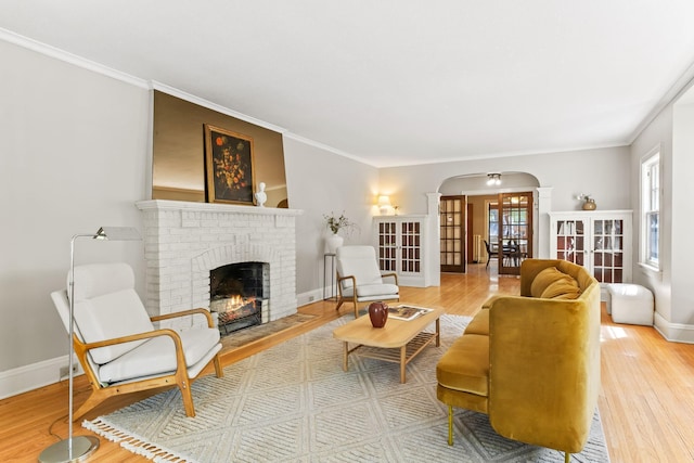 2901 Vincent Ave N, Minneapolis, MN 55411 - living area featuring arched walkways, a brick fireplace, wood finished floors, plenty of natural light, and crown molding